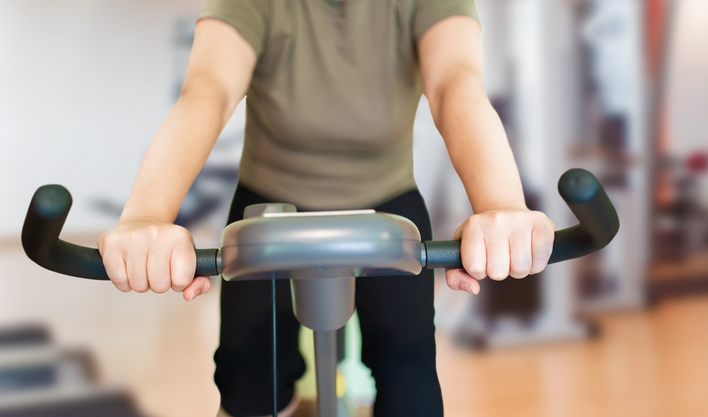 exercise and lupus photo of a woman on a stationary bicycle
